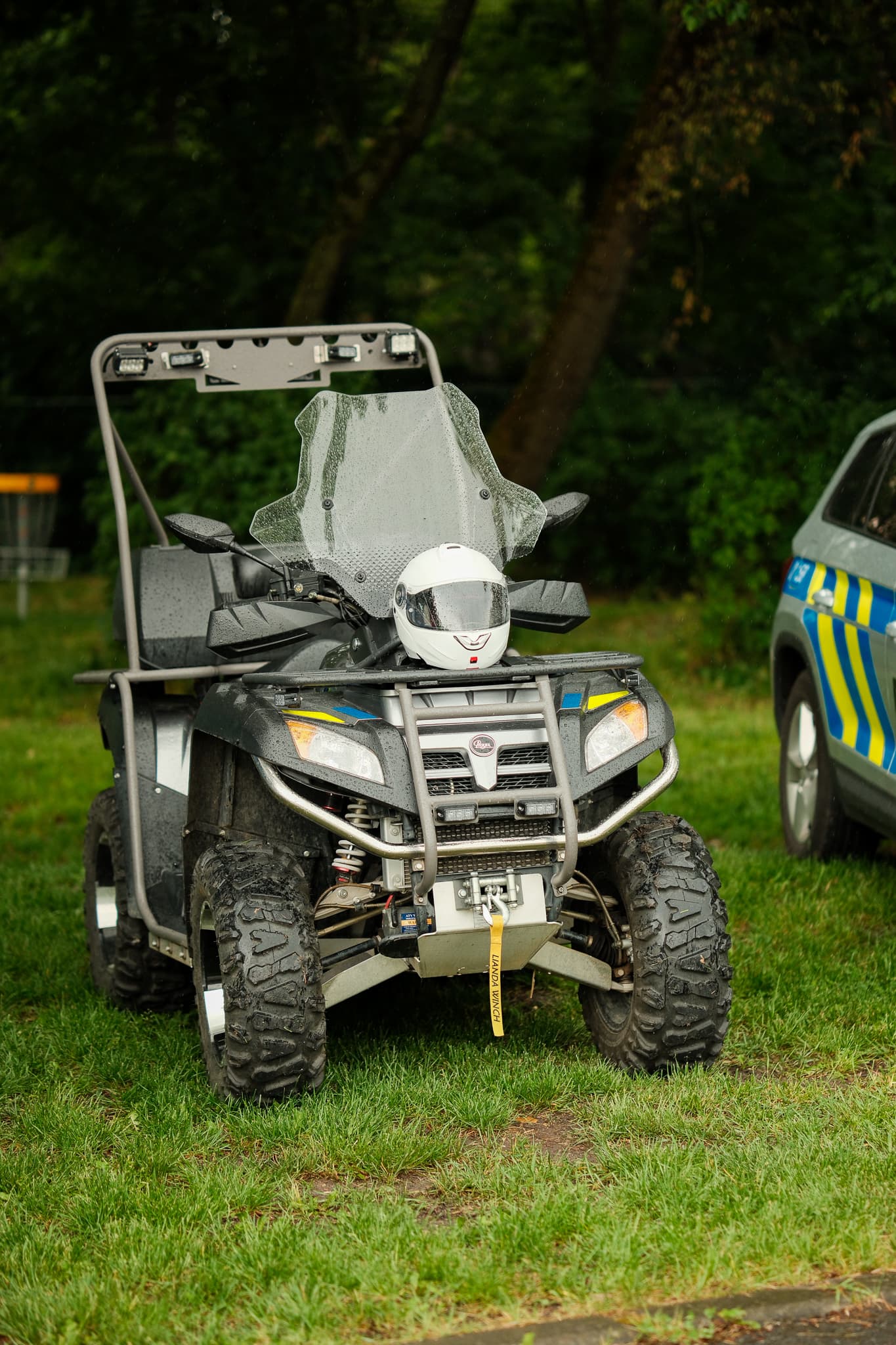 Policejní terénní čtyřkolka s bílou přilbou připravená pro děti k prohlídce
